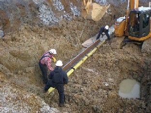 Construction workers installing natural gas pipe